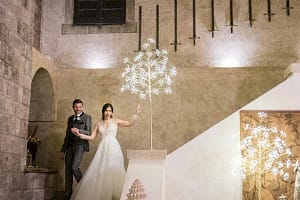 Gli sposi in un ingresso trionfale a Castello Monaci, illuminato dalle luci natalizie.