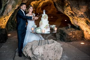 Momento magico del taglio della torta all'interno della suggestiva grotta durante un matrimonio al Gibò.